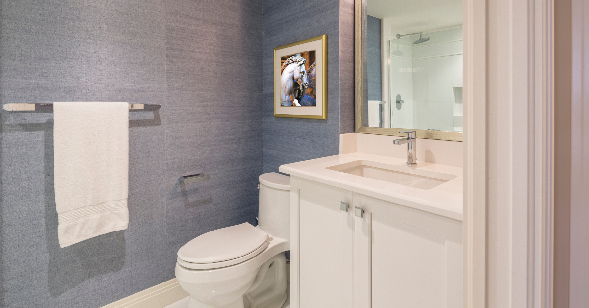 Bathroom remodeling in Vienna featuring a coastal look including white cabinets and blue grasscloth wallpaper.