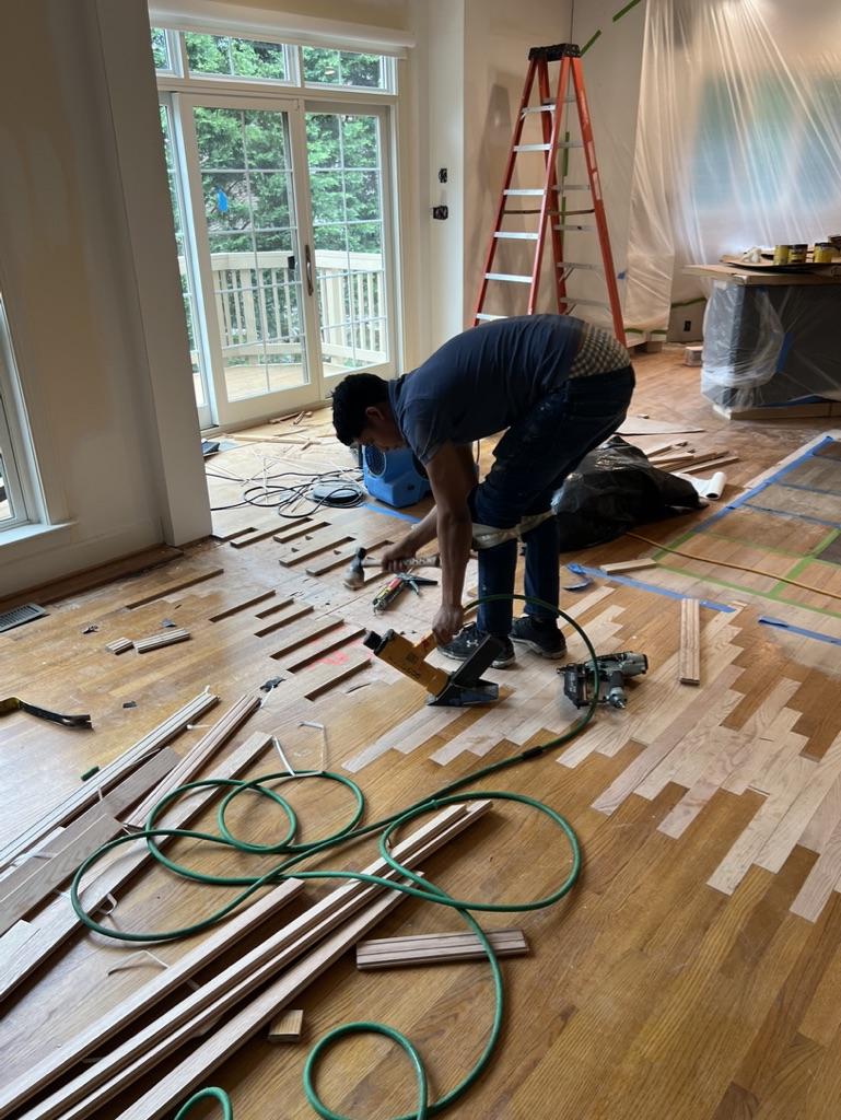 New sections of hardwood are added to the gap to create a seamless floor.