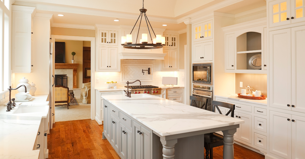 A modern traditional kitchen remodel featuring grey and white cabinets and marble countertops.